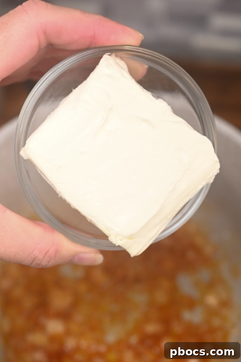 Garlic added to sautéed onions for cheesy ham broccoli rice casserole