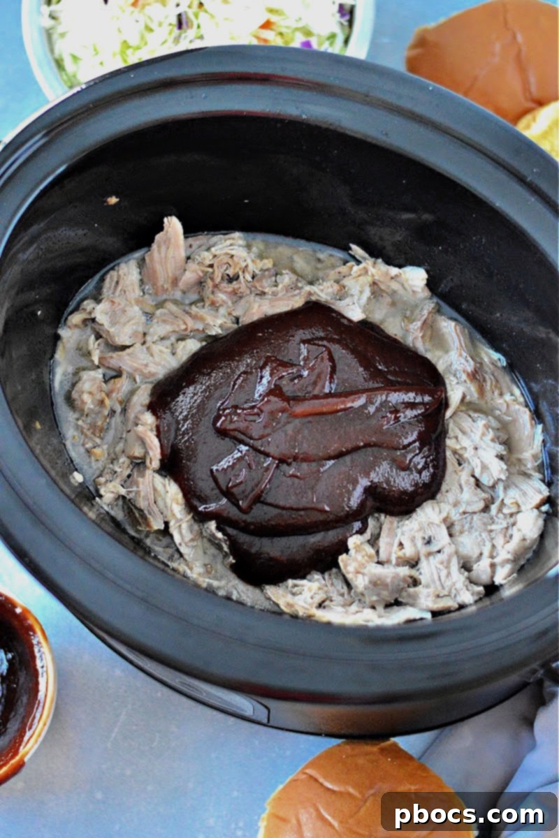 Step 6: Tossing shredded pork with keto BBQ sauce
