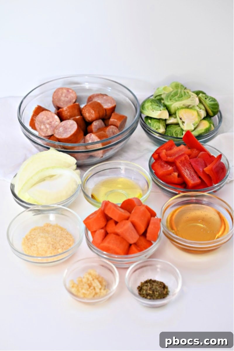 A collection of ingredients laid out, including sliced sausage, bell peppers, carrots, Brussels sprouts, and honey garlic sauce components, ready for the Low Carb Honey Garlic Sausage and Veggies recipe.