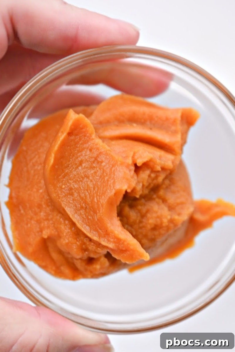 Mixing pumpkin puree and other ingredients for a smooth and creamy pumpkin filling for keto crescent rolls.