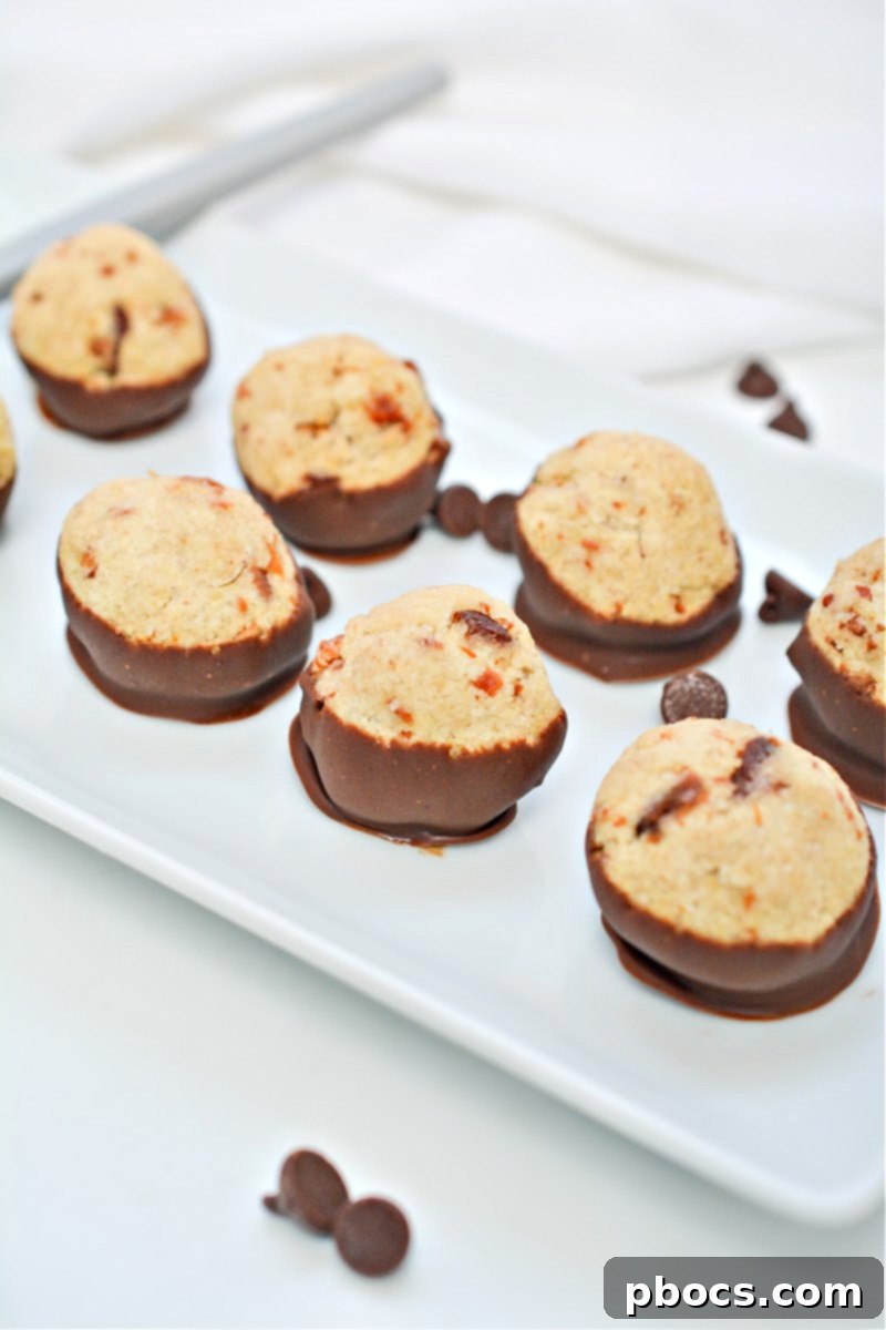 Close-up of freshly made Keto Maple Bacon Bites, showcasing their glossy chocolate coating and perfect round shape.