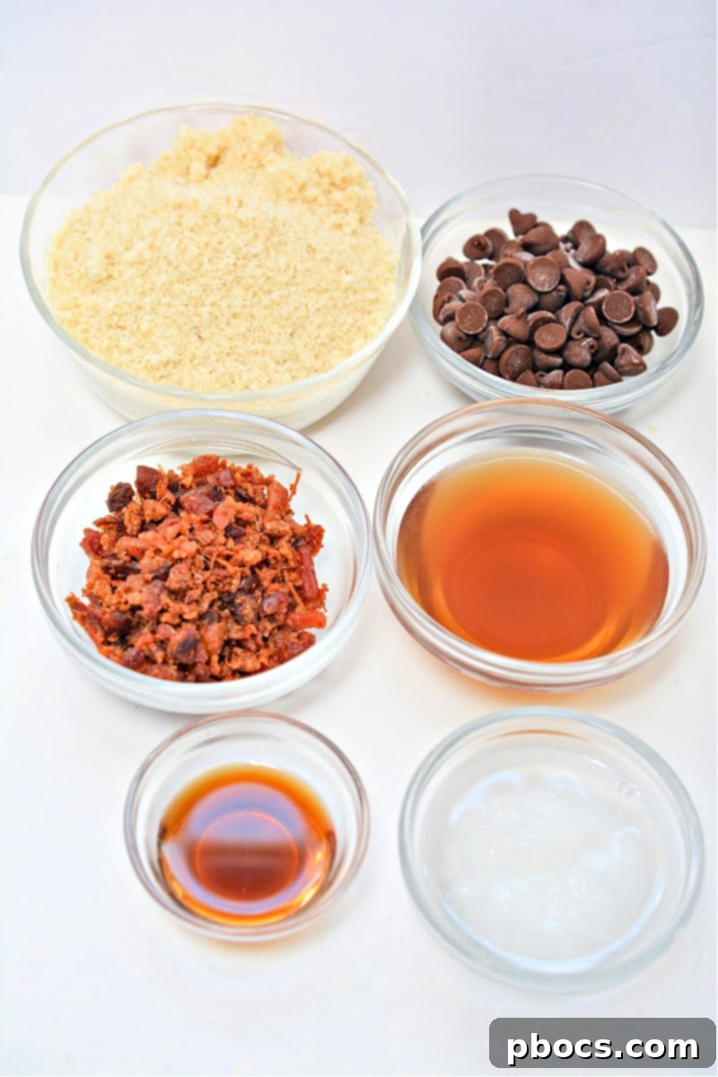 A flat lay of all the ingredients for Keto Maple Bacon Bites, including almond flour, sugar-free maple syrup, bacon, vanilla extract, coconut oil, and Lily's chocolate chips.