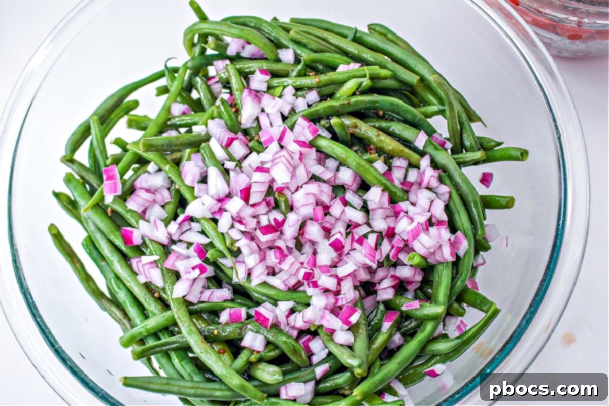 Adding the red onions to the marinated green beans