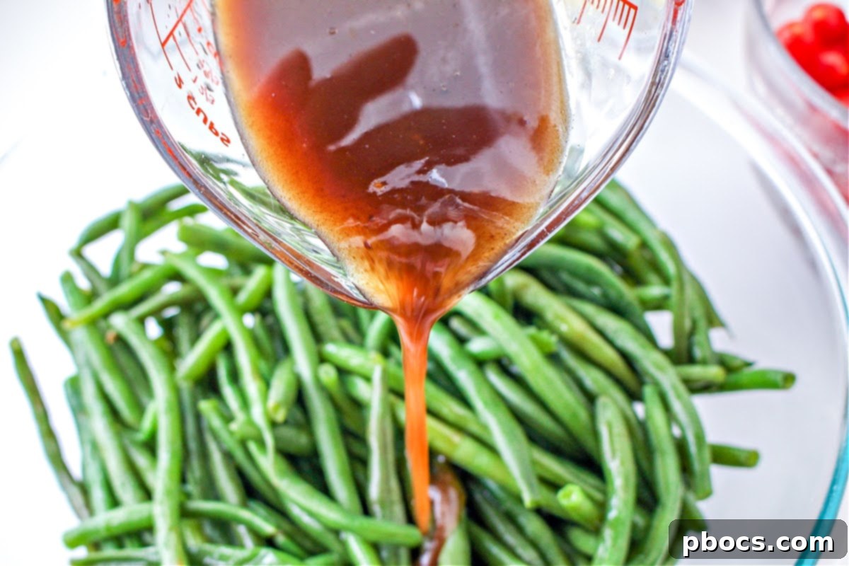 Pouring the balsamic vinegar dressing on the green beans