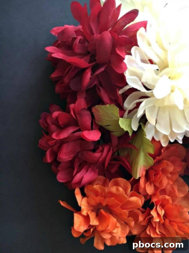 Hands pulling artificial flower heads off their stems, preparing them for the centerpiece.