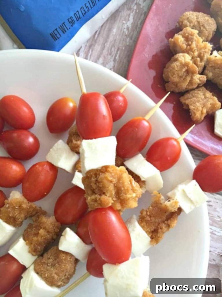 Artfully arranged chicken skewers with cherry tomatoes and mozzarella, accompanied by a bowl of cilantro jalapeño sauce.