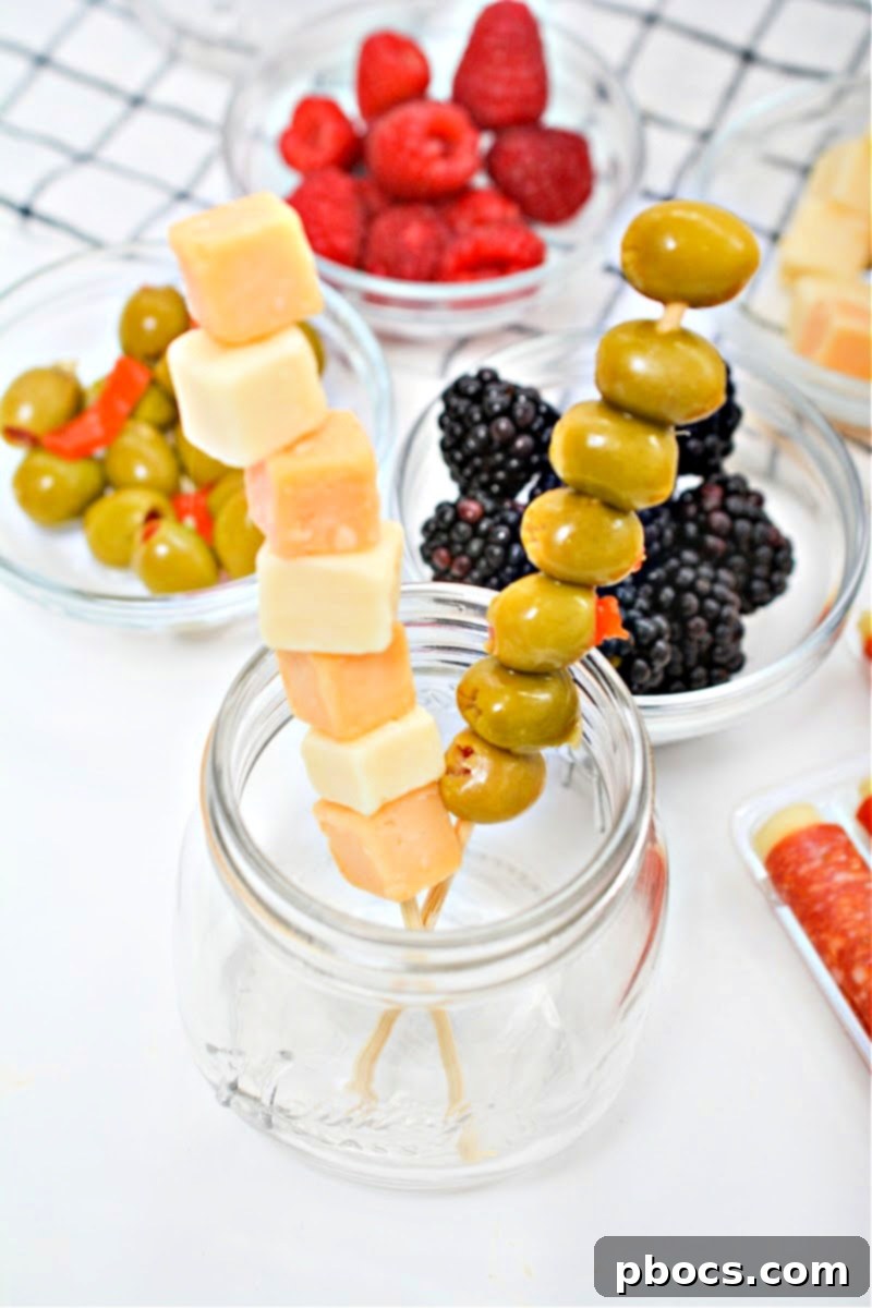 Adding a skewer of cheese to the mason jar.