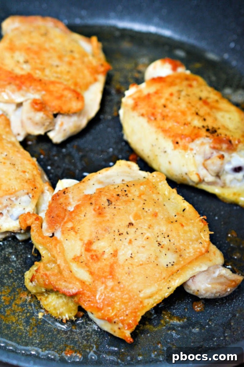 Chicken thighs searing in a skillet - Step 1
