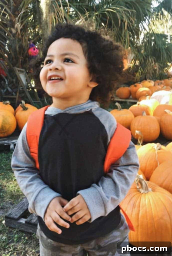 Joseph proudly showcasing his favorite pumpkin find at the patch