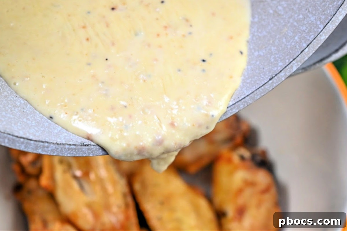 Adding Alfredo Sauce to the chicken wings