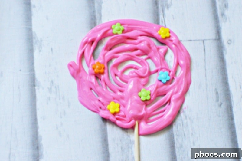 Adding Stick to Chocolate Pop Securing the lollipop stick onto the chocolate design