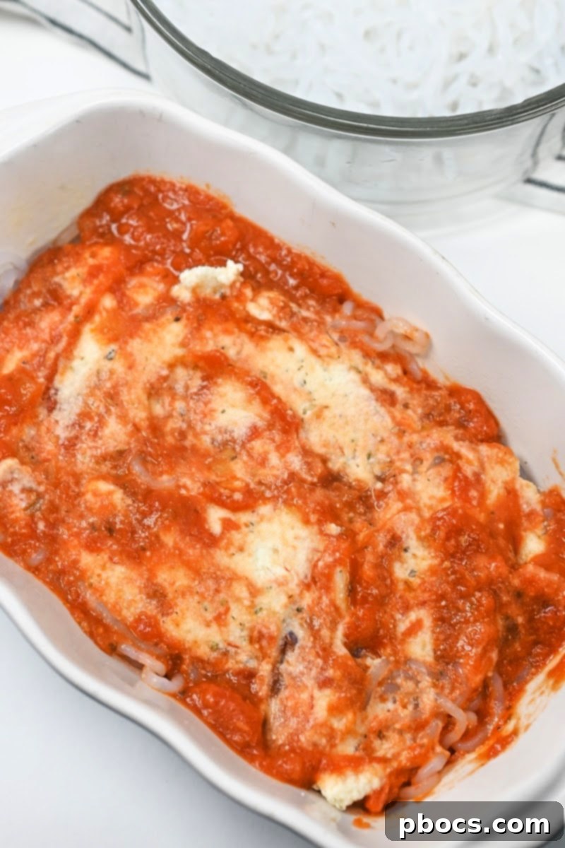 Keto Ramen Lasagna TikTok Style 11 Adding marinara sauce to the lasagna layers.