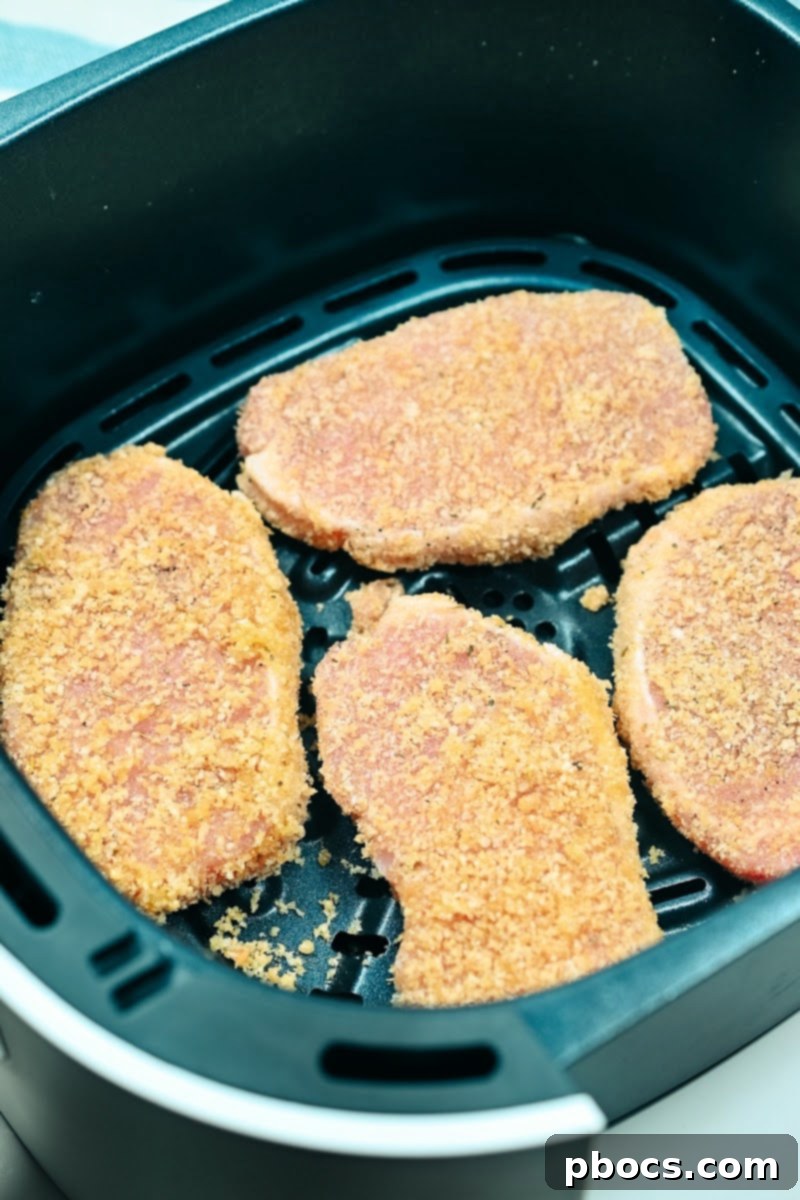 Air Fryer Golden Keto Pork Chops 10 coated raw pork chops in the air fryer