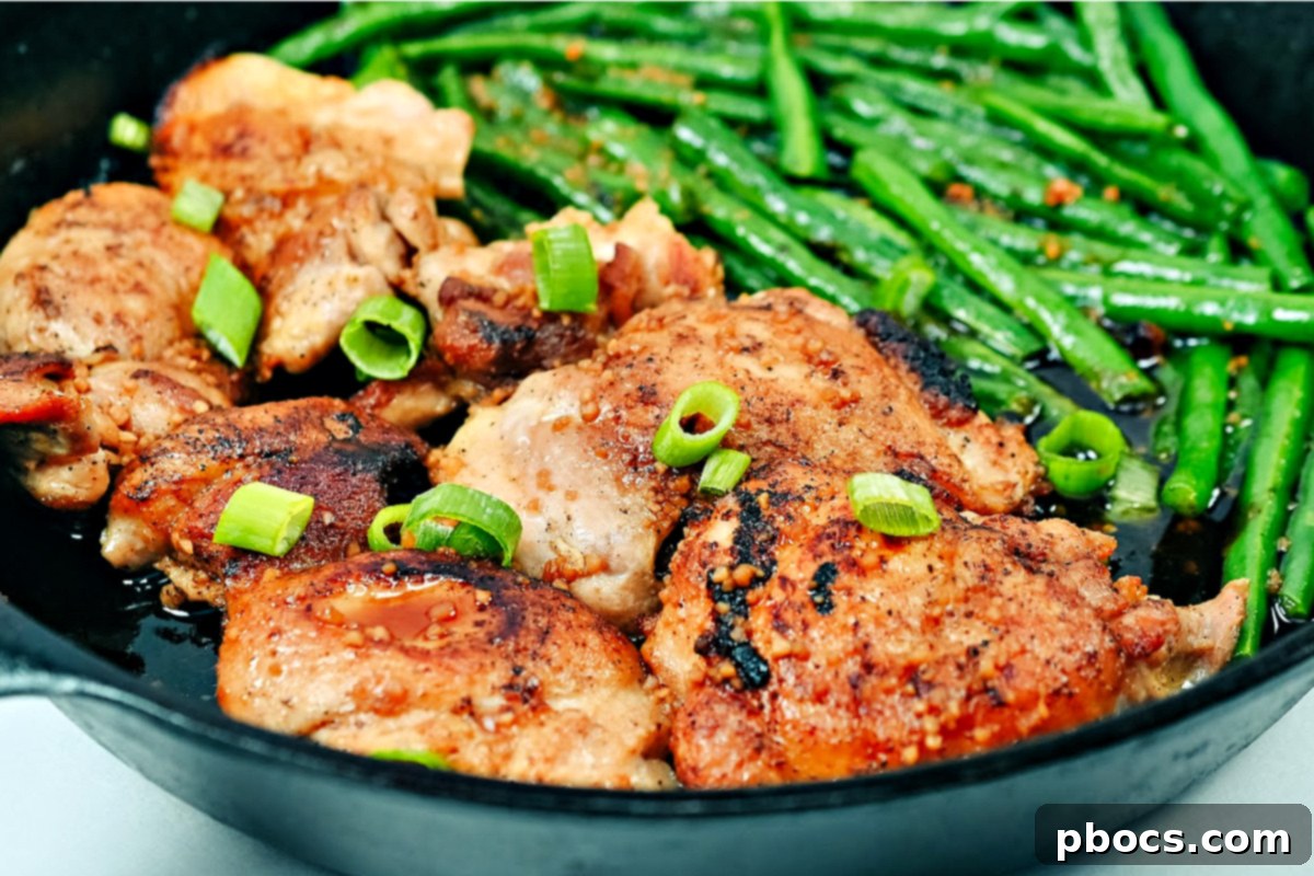 Keto Honey Garlic Chicken with Green Beans 12 The cooked chicken and green beans in a skillet, with the honey garlic sauce being poured over.
