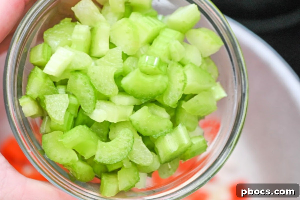 Diced celery, onion, and red bell pepper in a pot