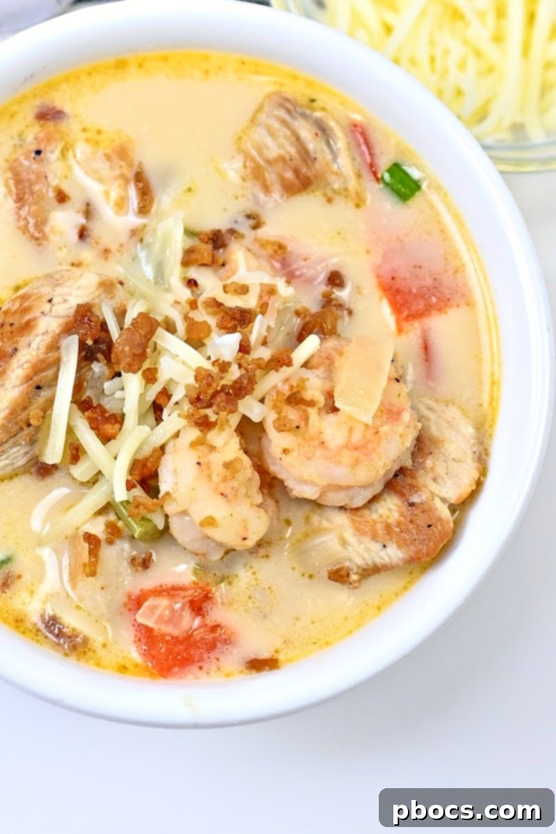 A bowl of Keto Cajun Chicken & Shrimp Soup garnished with green onions