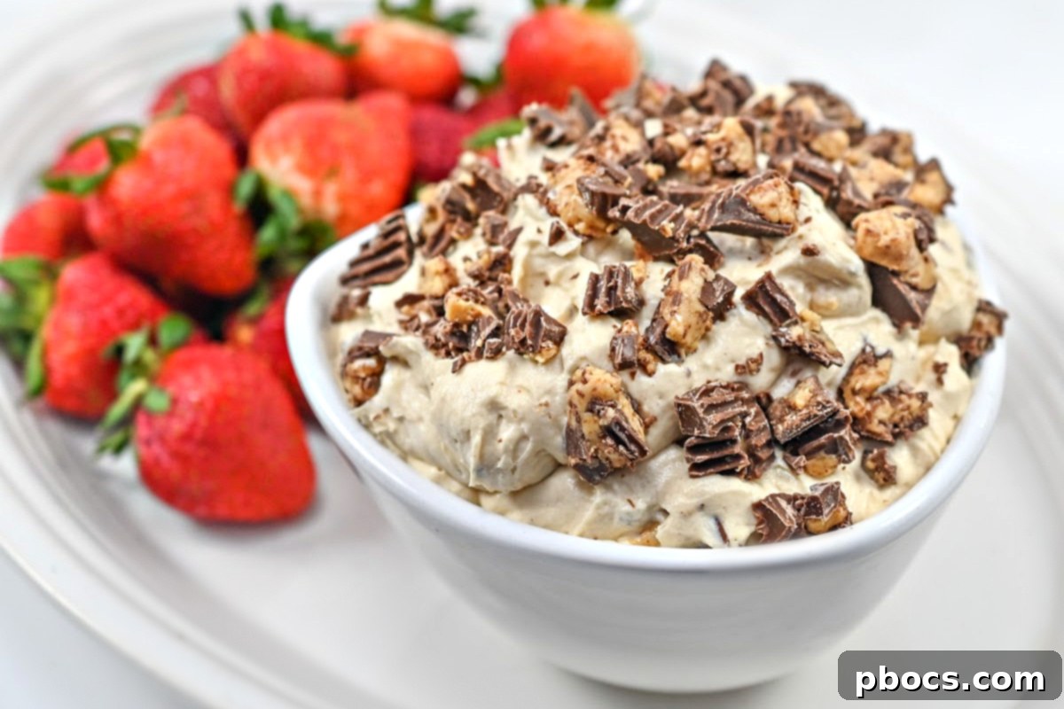 Keto Peanut Butter Chocolate Dip 3 Close-up of fluffy Keto Reese's Dip garnished with sugar-free peanut butter cups, served with fresh strawberries