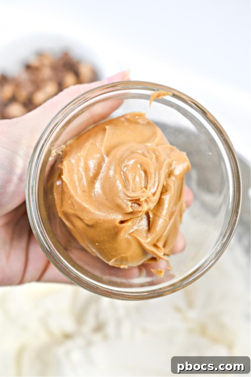 Keto Peanut Butter Chocolate Dip 10 Adding natural creamy peanut butter to the fluffy cream cheese mixture in a mixing bowl