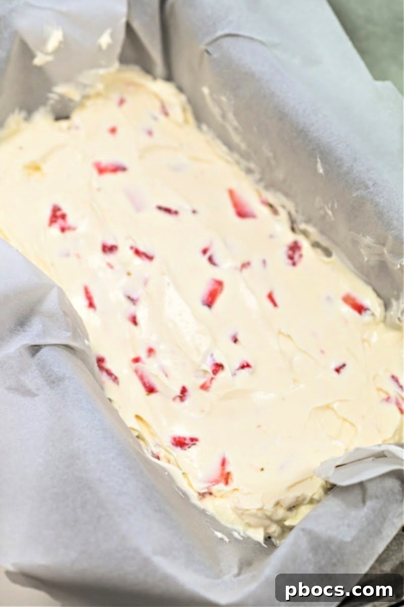 Decadent Keto Strawberry Fudge 12 Spreading Keto Strawberry Cream Fudge mixture into a parchment-lined loaf pan
