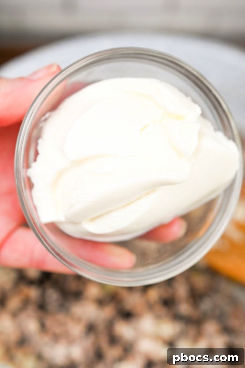 Keto Sausage Lasagna Pinwheels 11 Ricotta and Parmesan cheeses being mixed into the sausage filling