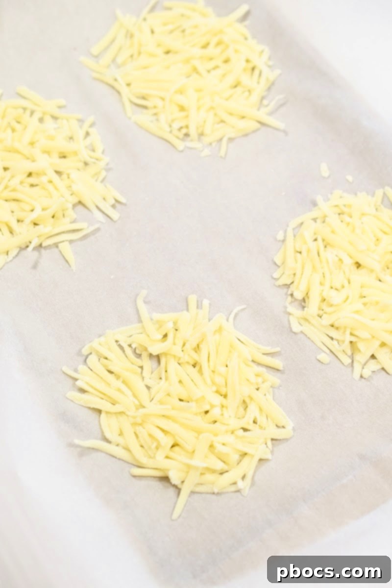 Keto Sausage Lasagna Pinwheels 12 Shredded mozzarella cheese formed into circles on parchment paper