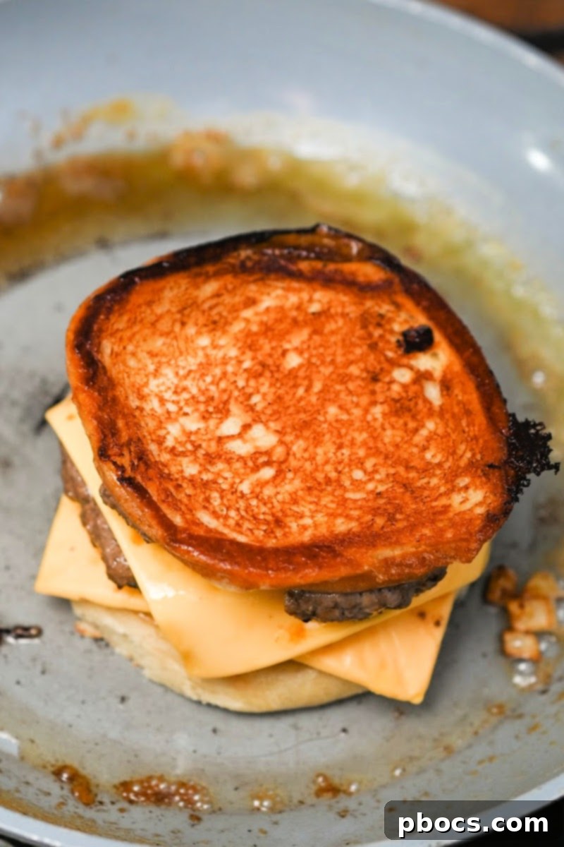Grilling the assembled keto cheeseburger grilled cheese in a skillet