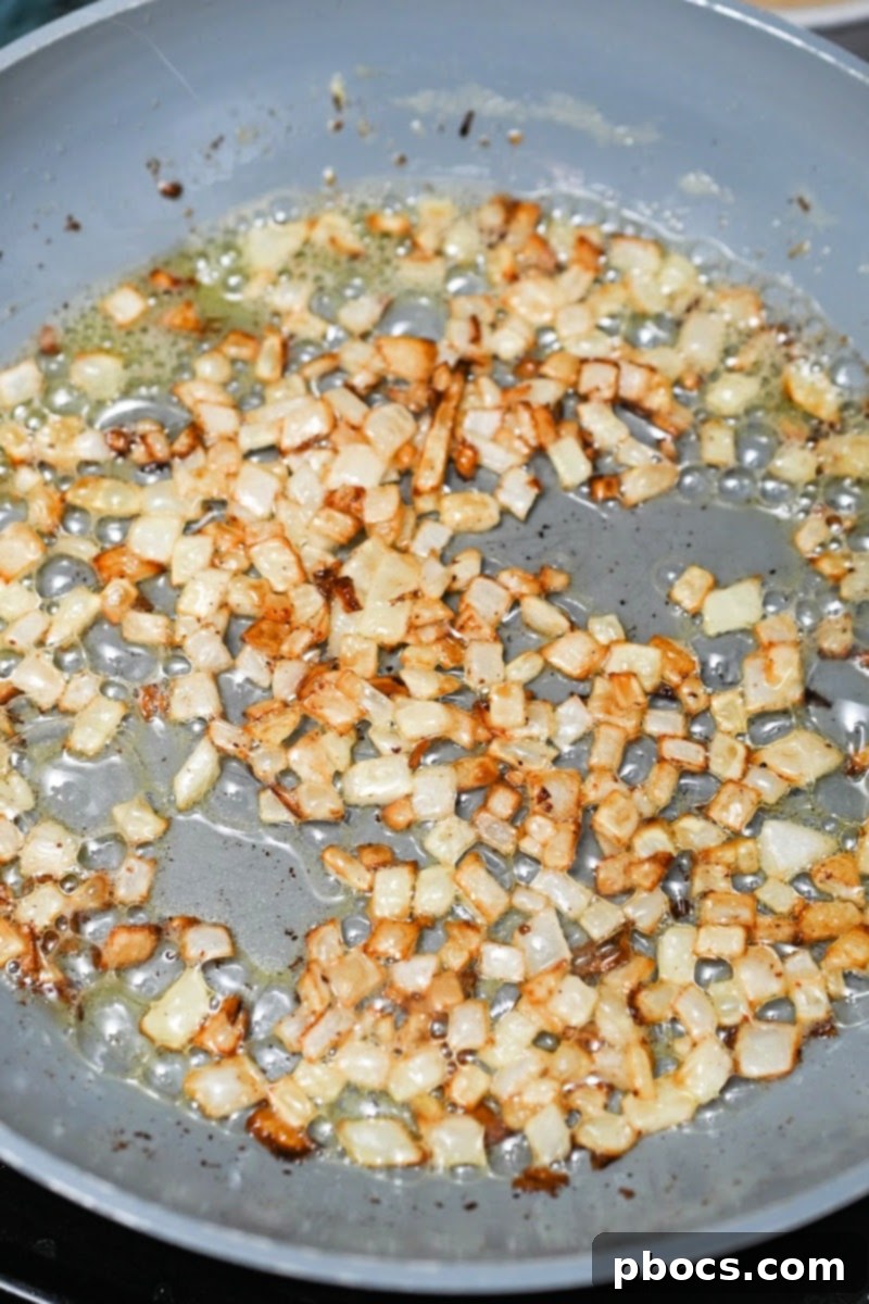 Sautéing diced onions in a skillet with butter