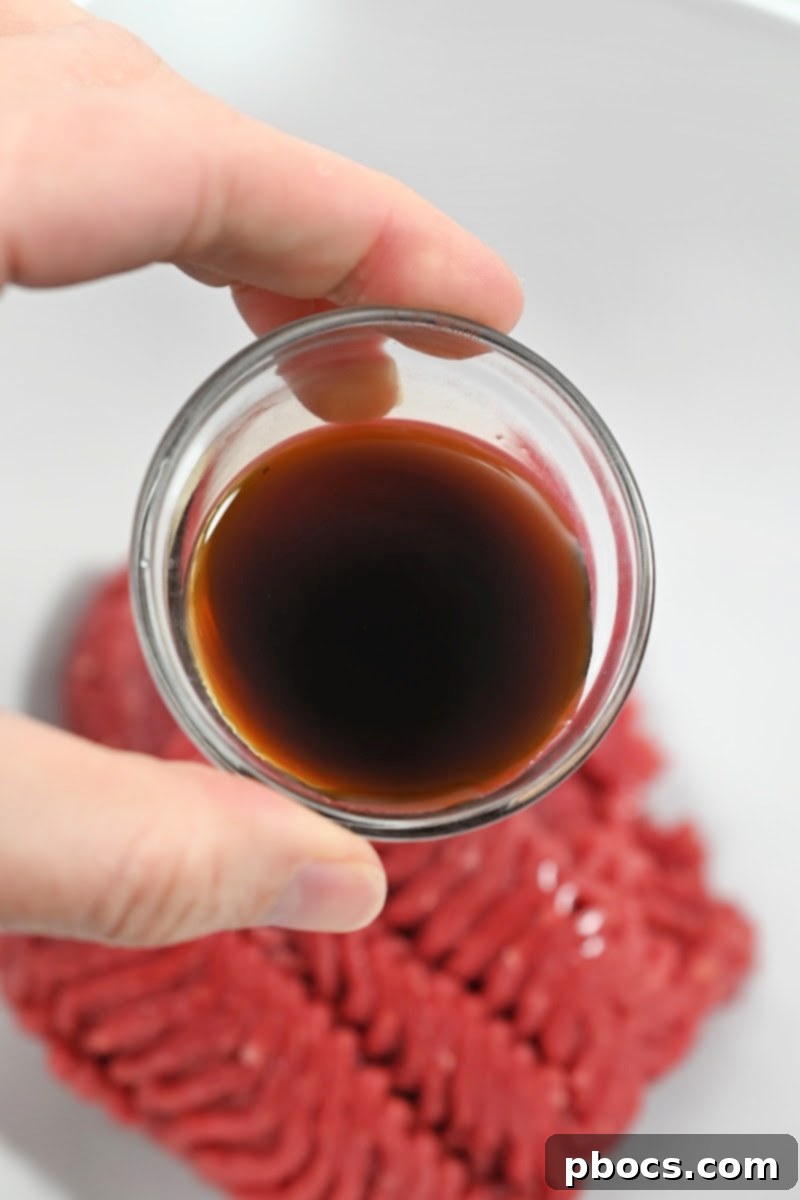 Mixing ground beef with seasonings in a bowl