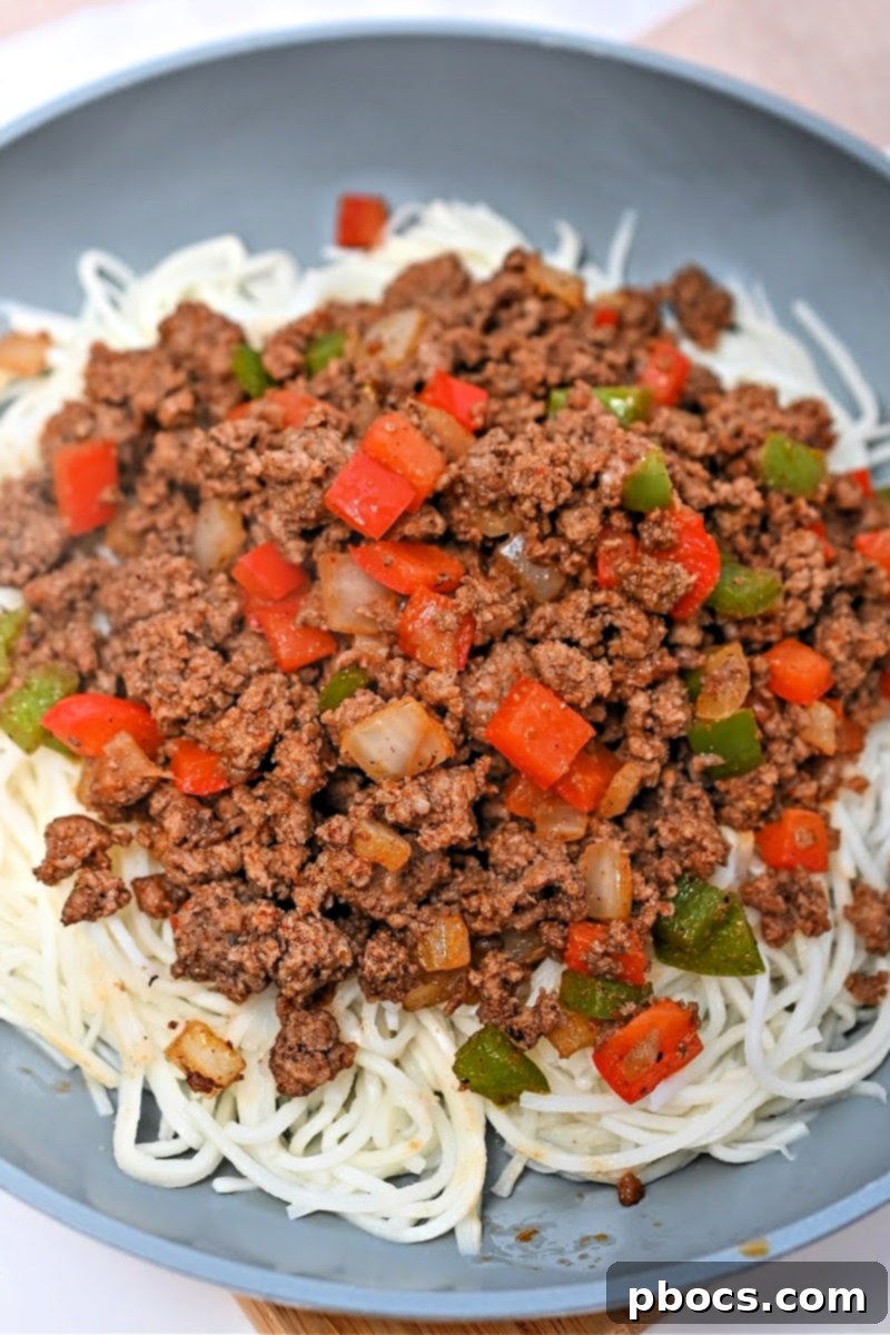 Palmini noodles being sautéed in a separate skillet with oil