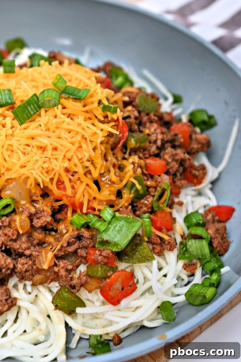 Keto Taco Spaghetti garnished with cheese and green onions