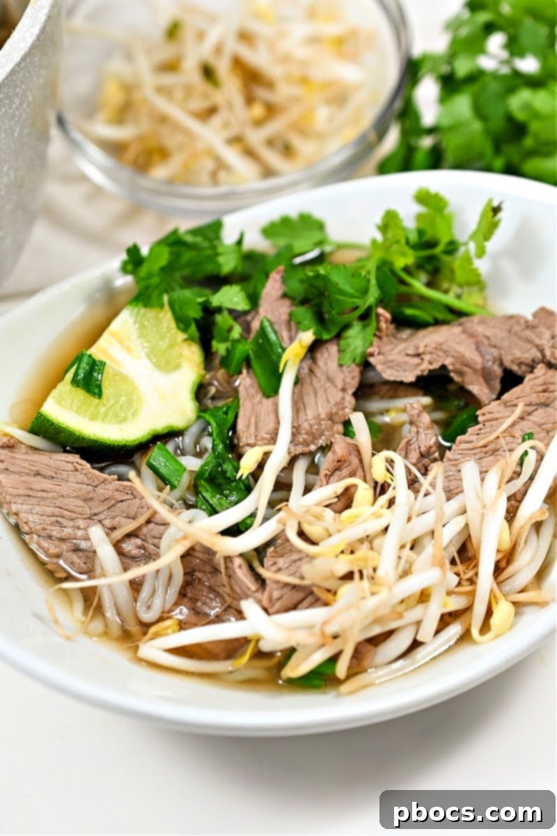 A comforting bowl of Keto Beef Pho, garnished with fresh herbs