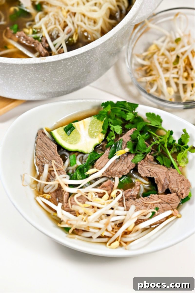 Keto Beef Pho in a clear bowl, highlighting its rich color and ingredients