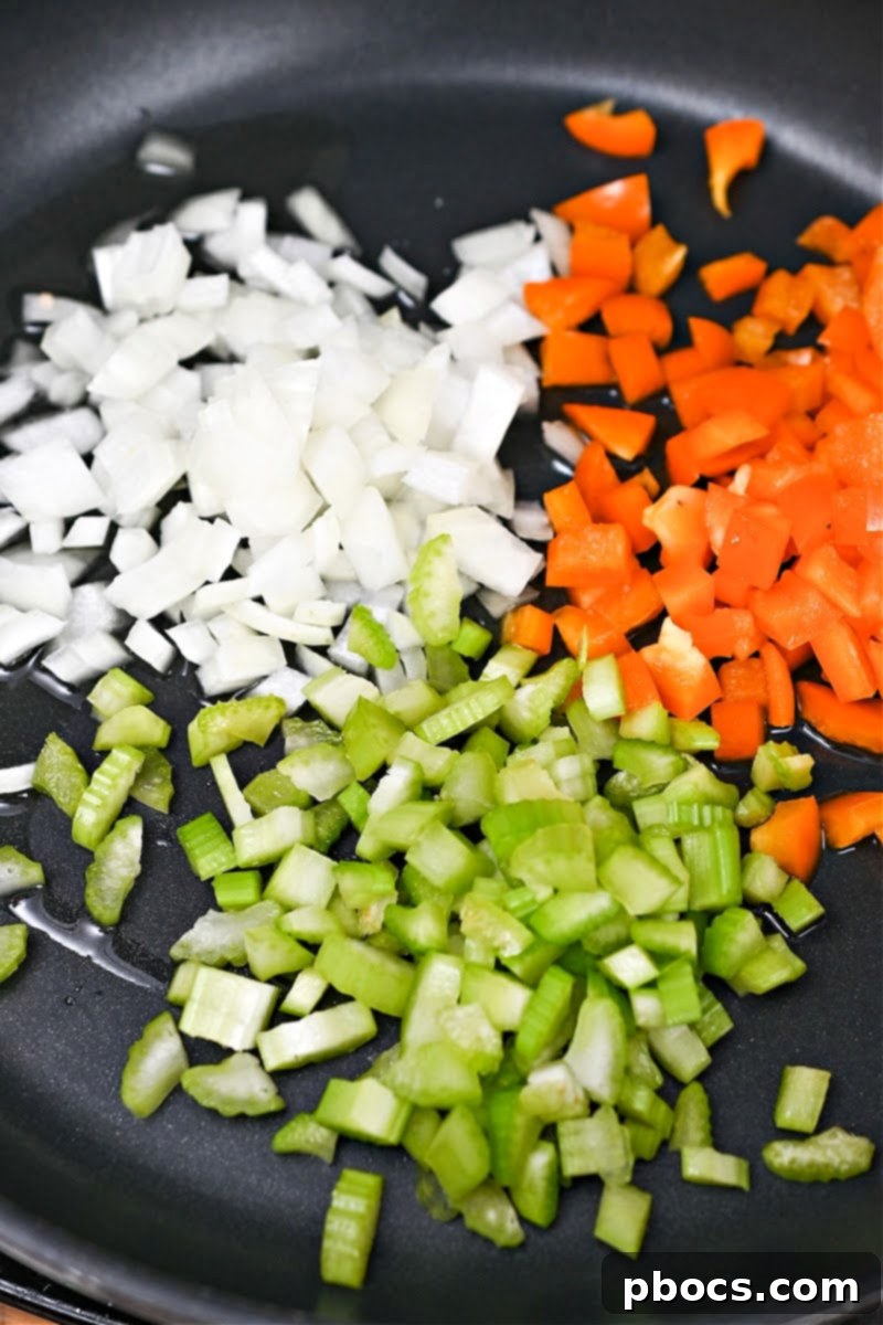Adding peppers, onion, and celery to the skillet to sauté for the Keto Jambalaya.