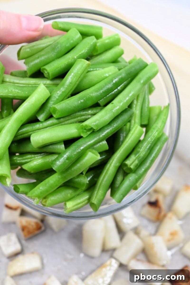 Chopped green beans ready to be added to the baking sheet