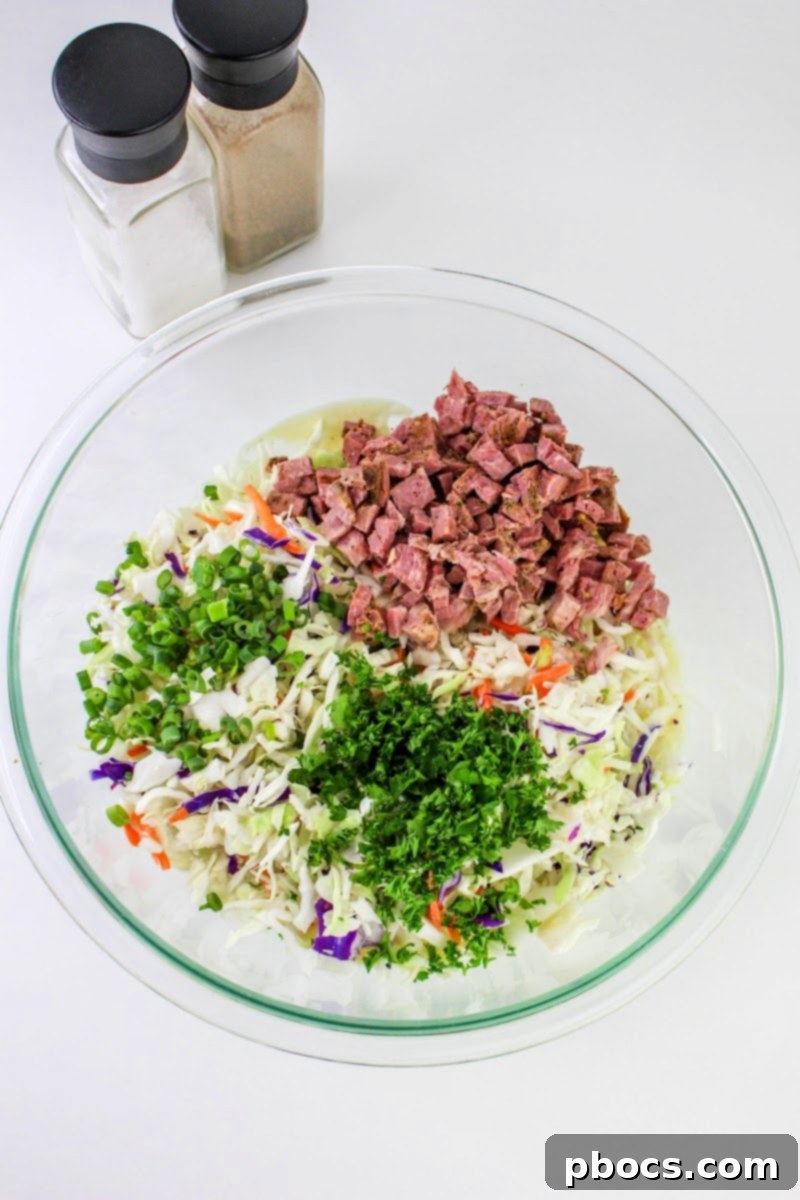 Mixing all ingredients for Low Carb Corned Beef Slaw in a bowl