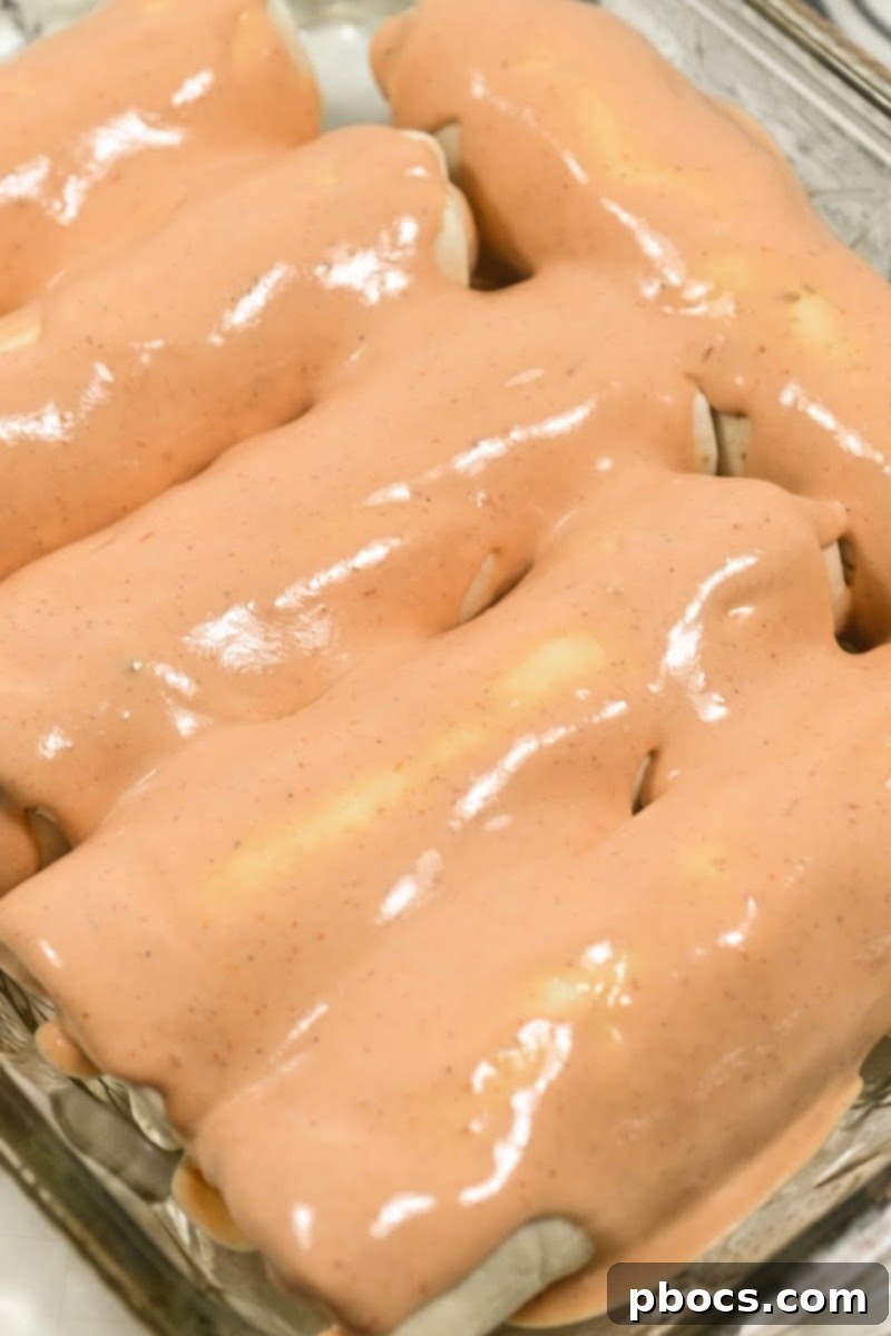 Pouring sauce over Keto Crack Chicken Enchiladas