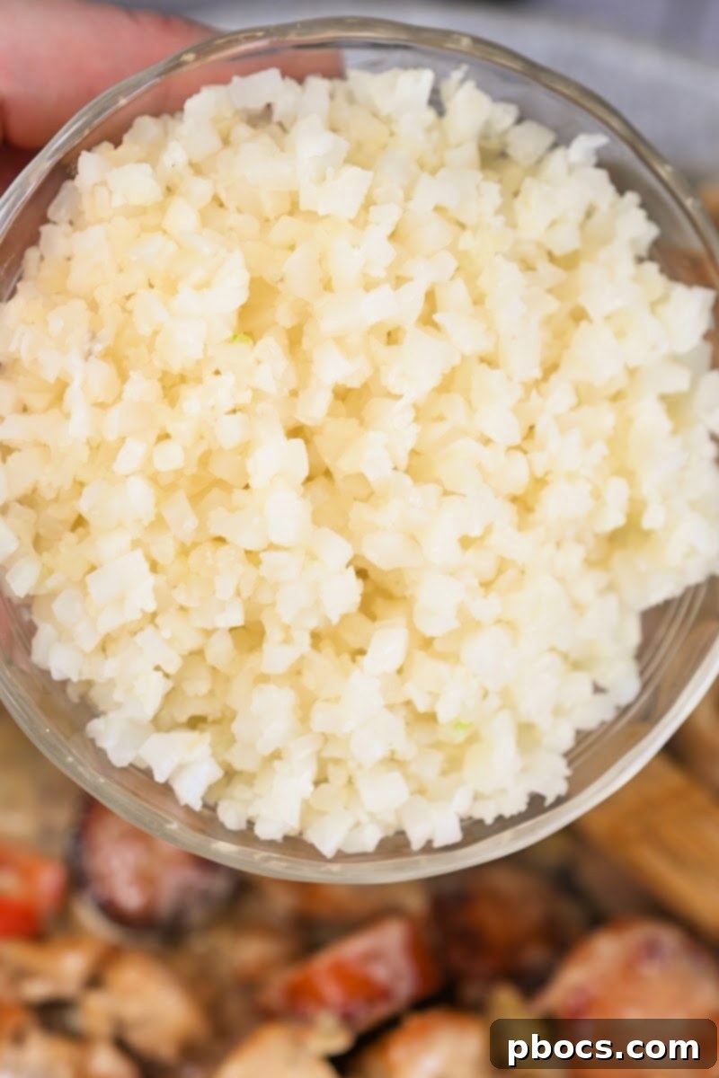 Adding cauliflower rice to the Keto Cajun Alfredo Skillet