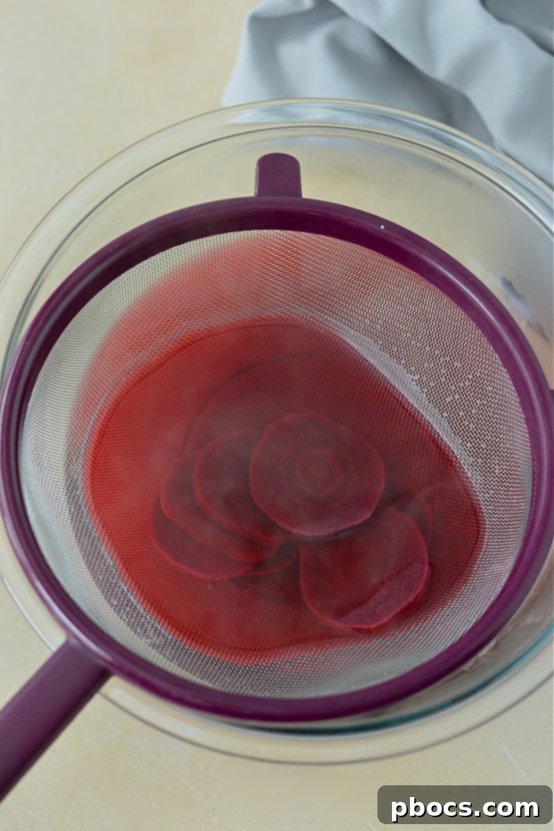 Straining the beet mixture after simmering for the pickled eggs