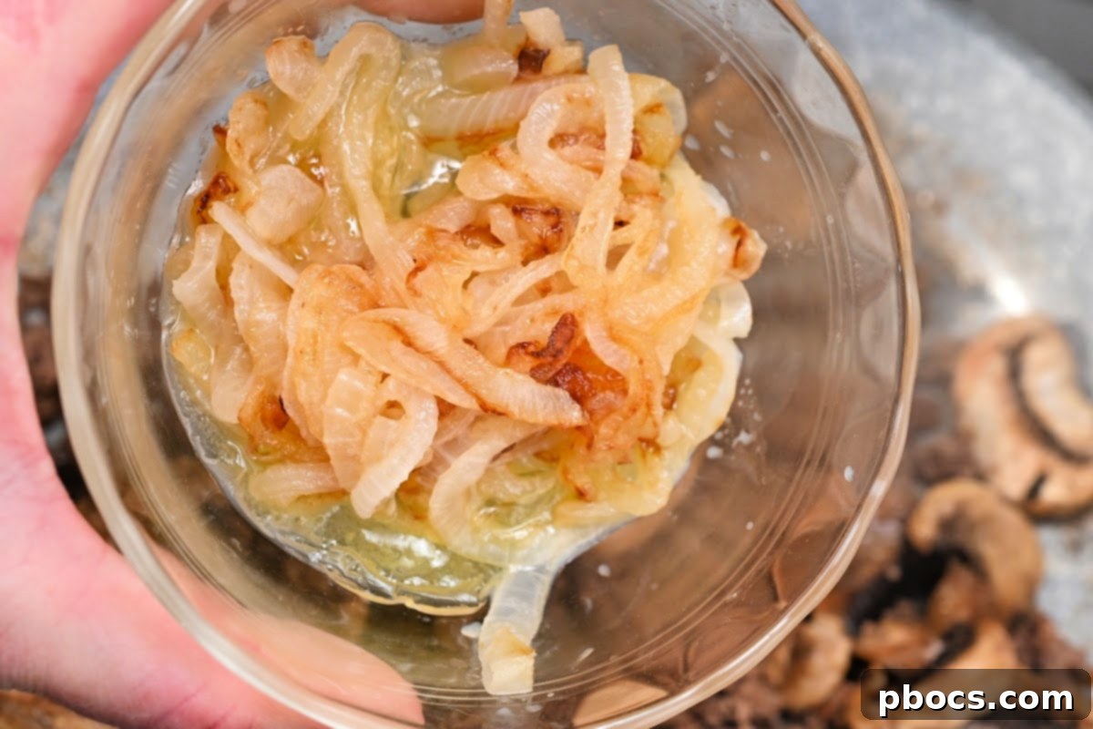 Sliced onions caramelizing in a pot with butter for French onion pasta