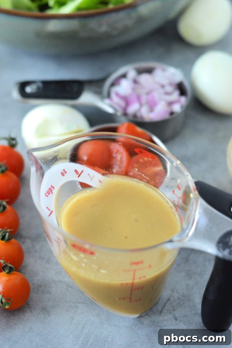 Savory Honey Mustard Chicken Salad Bites 11 Low-Carb Honey Mustard Chicken Salad dressing being drizzled over fresh ingredients