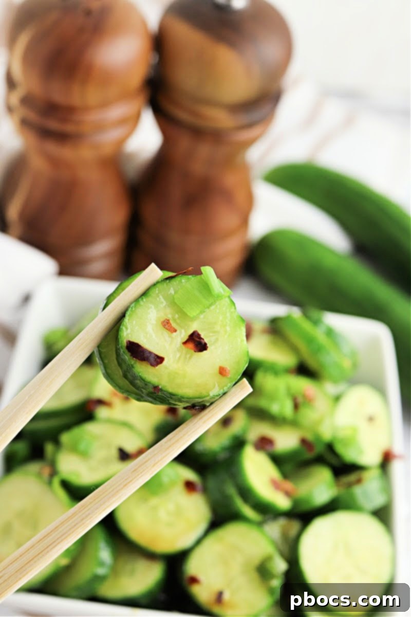 Vibrant Korean Cucumber Salad 2 Delicious Keto Korean Cucumber Salad served in a white bowl, garnished with green onions and red pepper flakes
