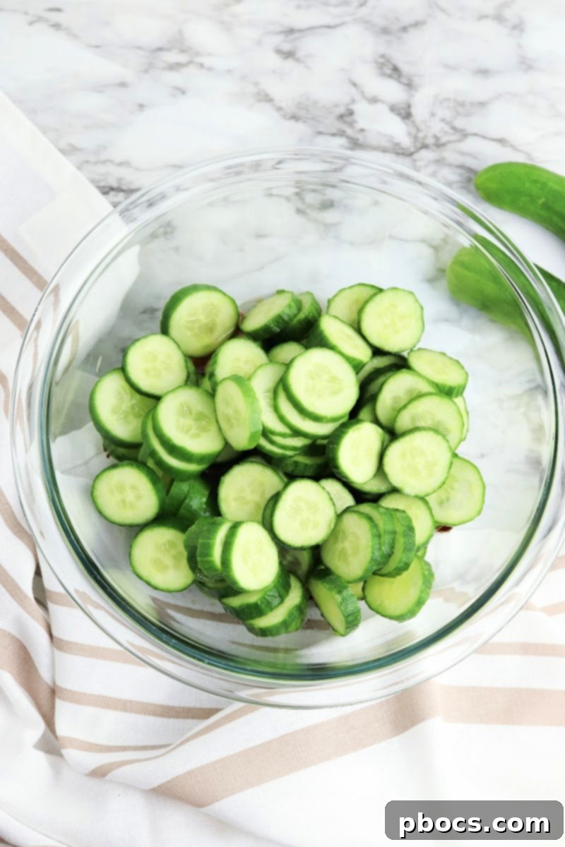 Vibrant Korean Cucumber Salad 10 Sliced mini cucumbers and chopped green onions being mixed into the prepared dressing in a bowl