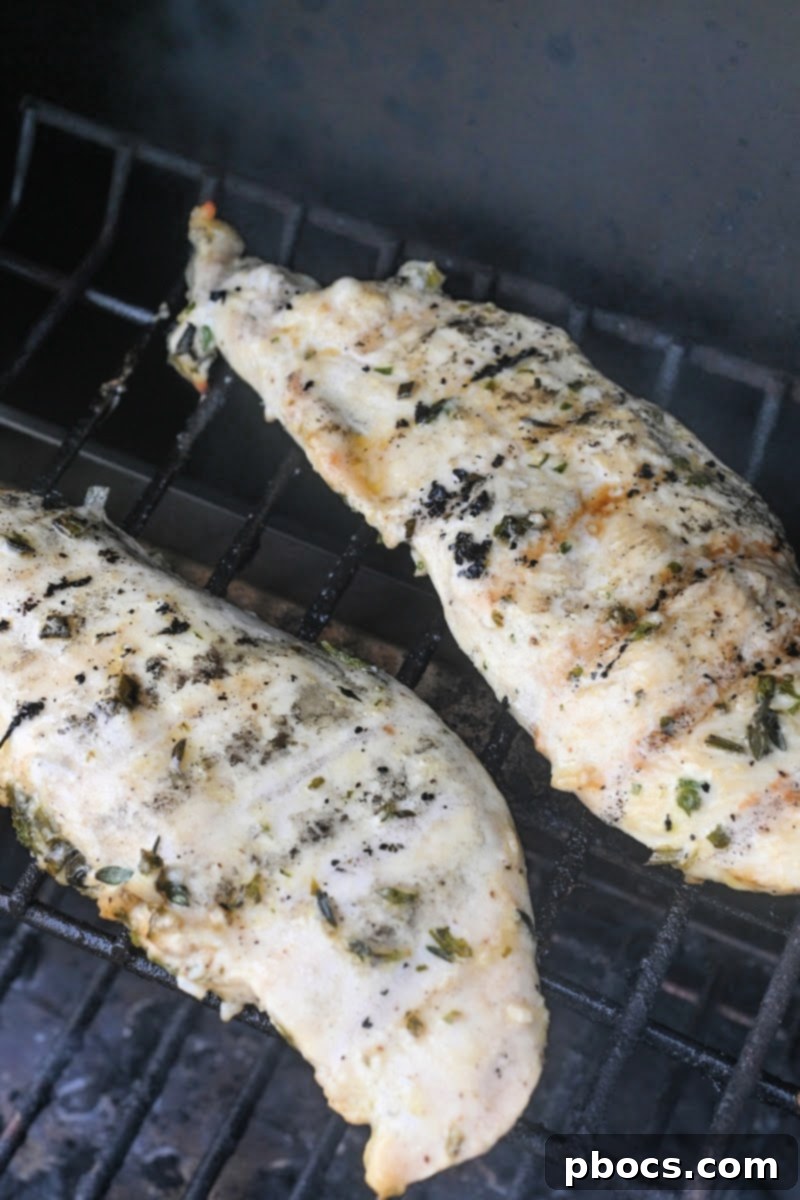 Grilling Lemon Herb Chicken - Chicken breasts cooking on a hot grill.