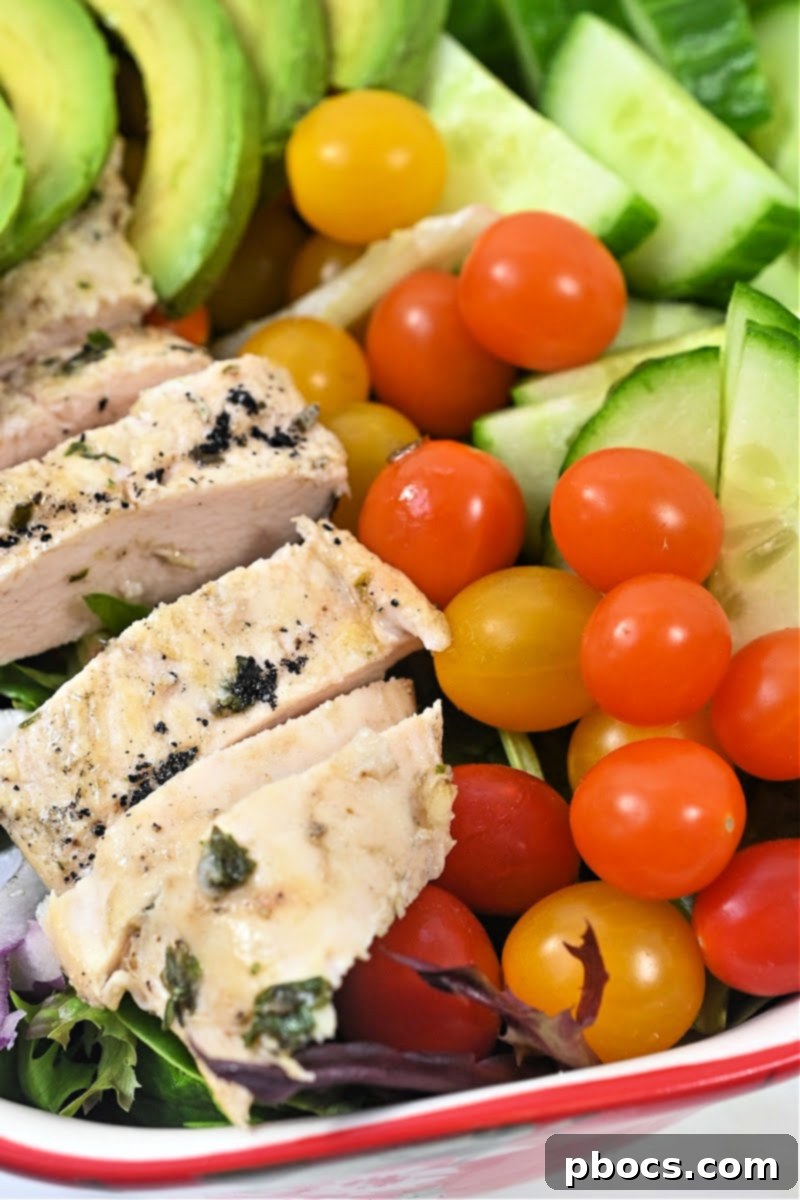 Assembling Keto Lemon Herb Chicken Salad - Greens and toppings in a large bowl.