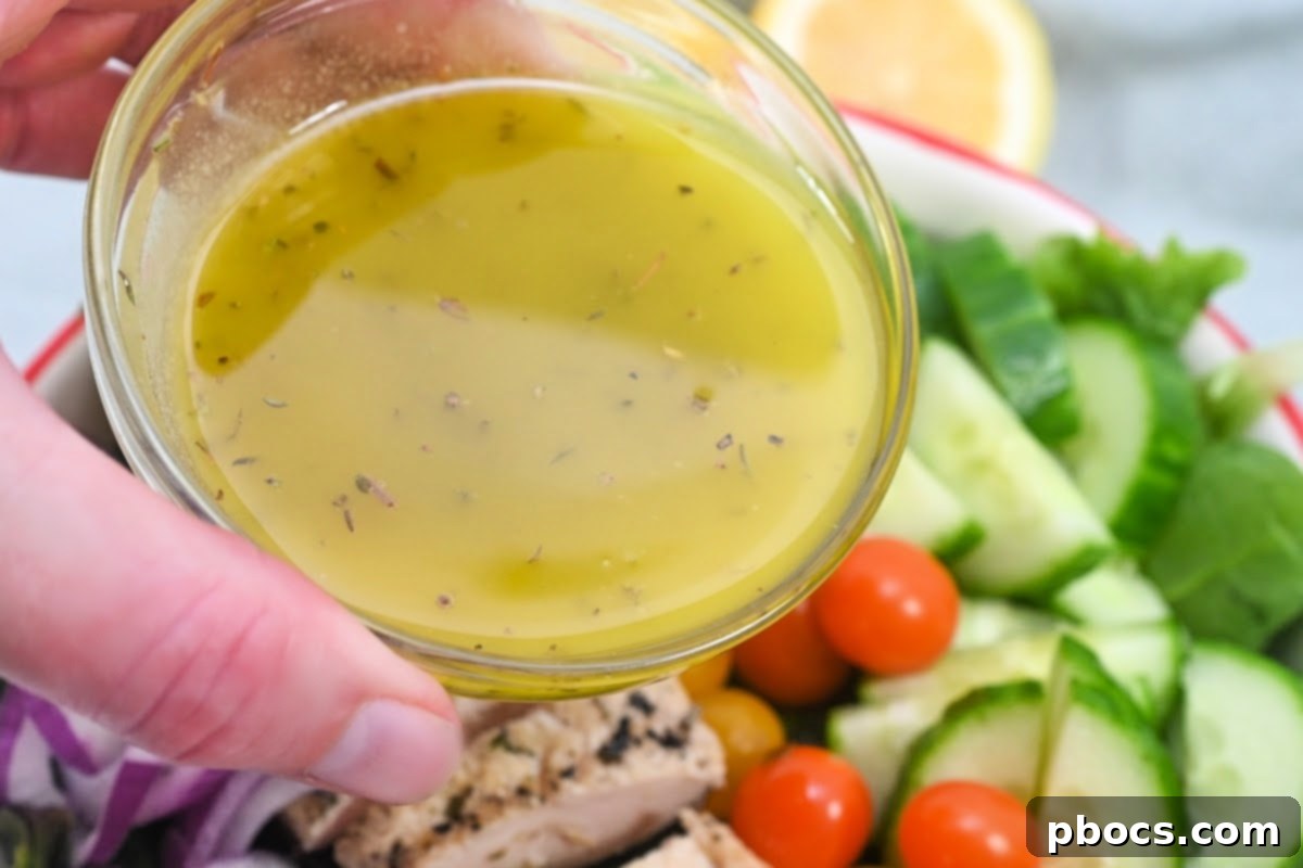 Drizzling Lemon Herb Dressing over the Salad - Final touch for a fresh meal.