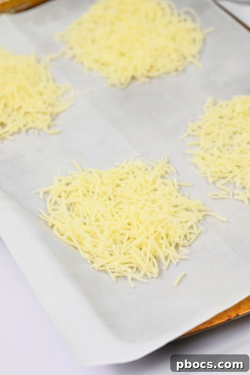 Shredded Swiss Cheese arranged on a parchment-lined baking sheet