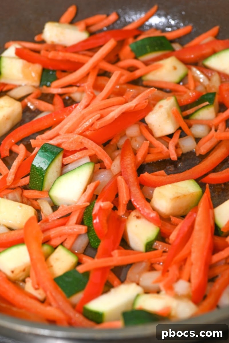 Cooking zucchini with the carrots and peppers