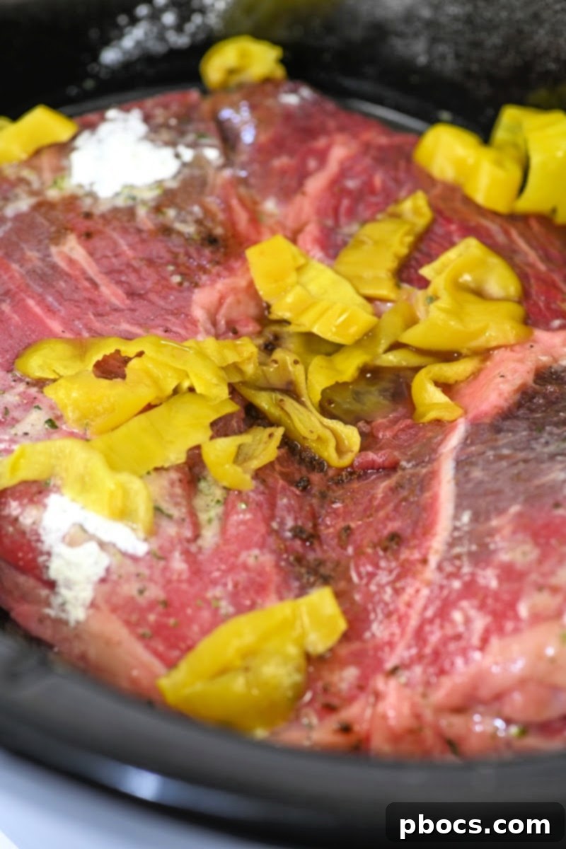 Adding peppers to the raw pot roast