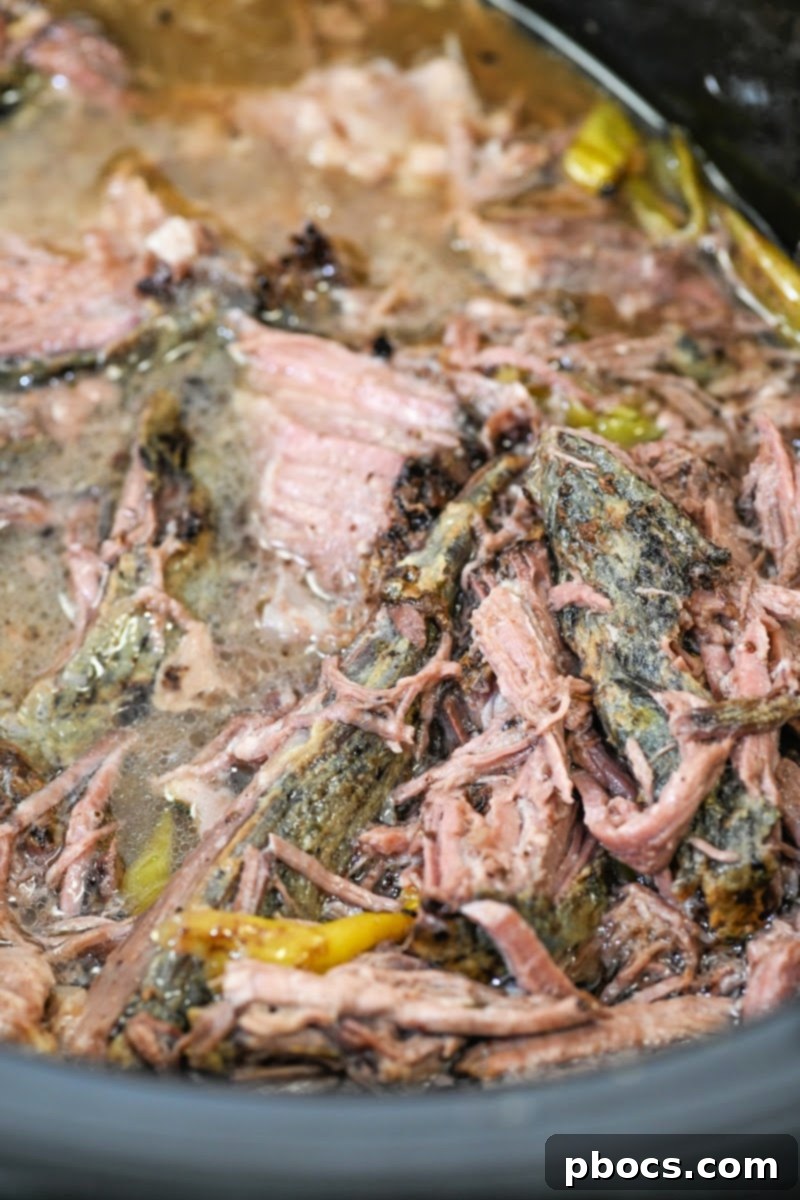 Cooked pot roast in the slow cooker, shredded