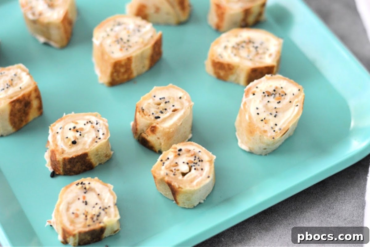 Keto Cream Cheese Bagel Poppers 12 Step 5: Slicing the chilled tortilla log into uniform pinwheels and arranging them in an air fryer basket.
